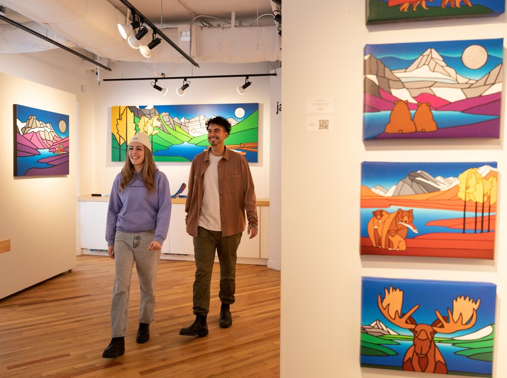 Two people walk through the Ryan Carter Gallery in Banff National Park.